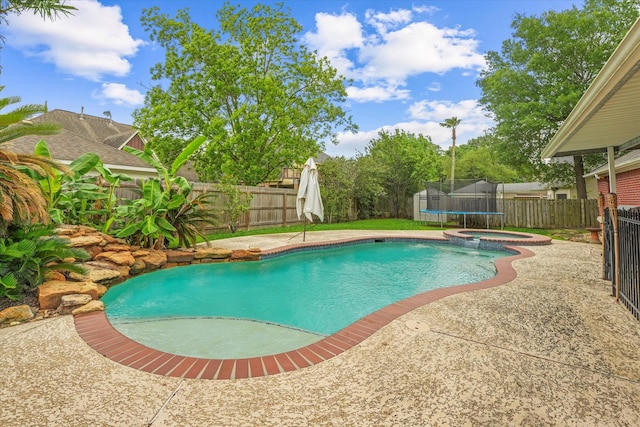 view of pool with a fenced backyard, a patio, and a pool with connected hot tub