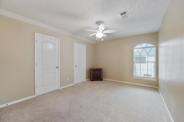 spare room featuring baseboards, ceiling fan, carpet, and visible vents