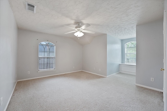 empty room with a ceiling fan, a textured ceiling, visible vents, baseboards, and carpet flooring