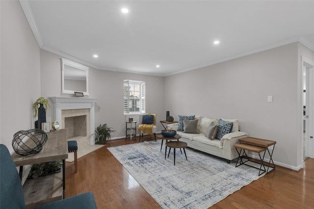living area featuring crown molding, recessed lighting, baseboards, and wood finished floors