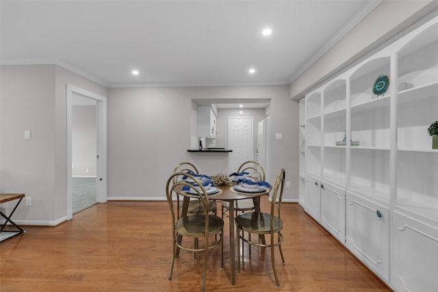 dining room featuring recessed lighting, ornamental molding, baseboards, and wood finished floors
