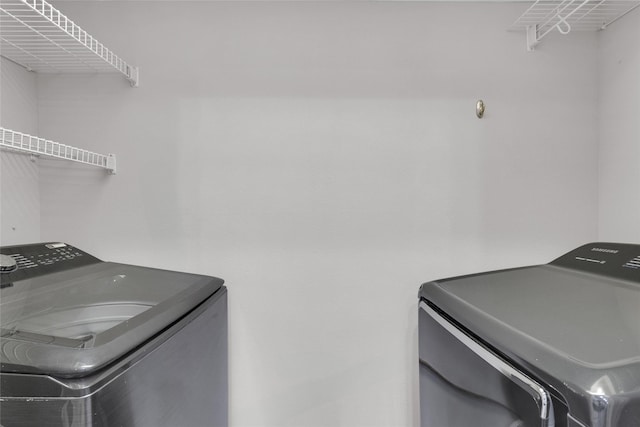 clothes washing area featuring washing machine and clothes dryer and laundry area