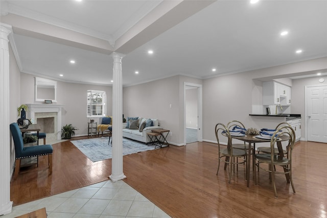 living room with crown molding, recessed lighting, decorative columns, and a fireplace