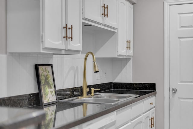 kitchen with a sink, dark countertops, white cabinetry, and dishwasher