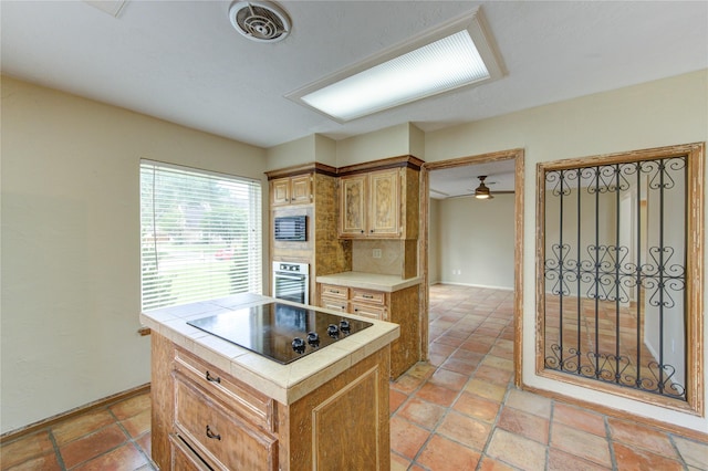 17522 Sorrel Ridge Dr, Spring, TX 77388 - kitchen featuring tile countertops, black electric cooktop, oven, and baseboards