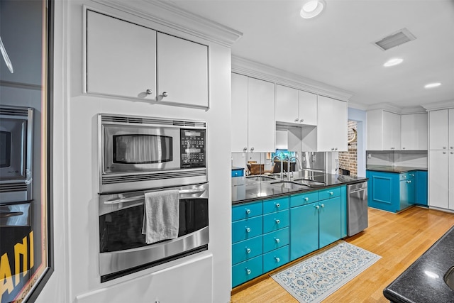 kitchen featuring visible vents, a sink, dark countertops, and stainless steel appliances