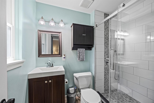full bath featuring vanity, a shower stall, toilet, and visible vents