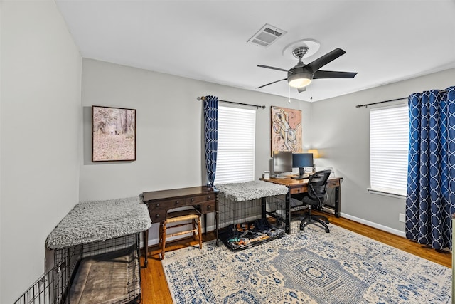 office space with visible vents, a ceiling fan, plenty of natural light, and wood finished floors
