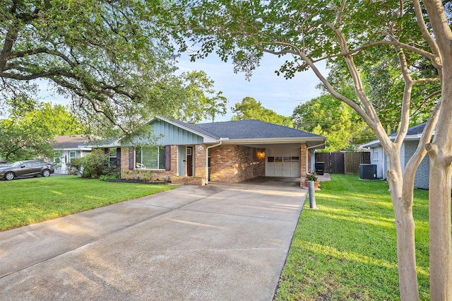 ranch-style home with driveway, a front yard, central AC unit, brick siding, and fence