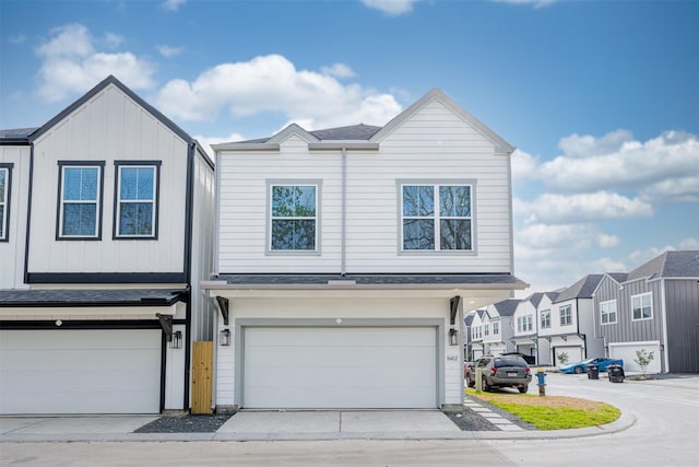 townhome / multi-family property with an attached garage, driveway, and a residential view