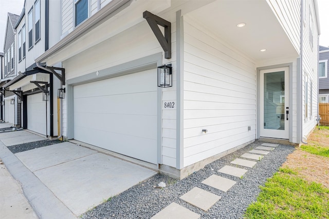 property entrance with an attached garage and concrete driveway