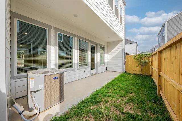 exterior space with a patio, a fenced backyard, and cooling unit