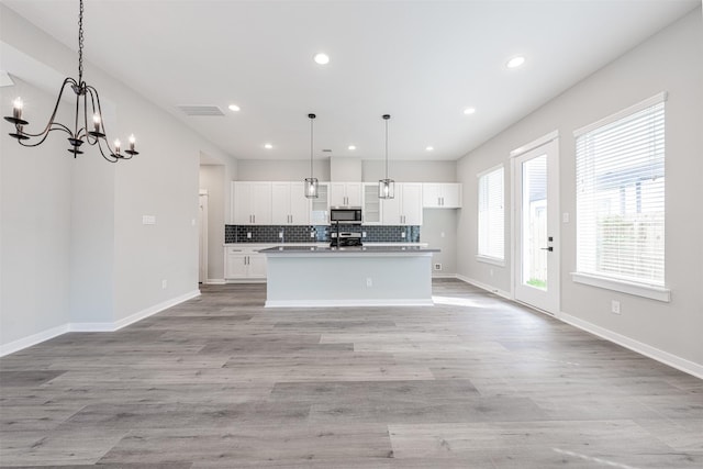 kitchen with decorative backsplash, open floor plan, recessed lighting, white cabinetry, and appliances with stainless steel finishes
