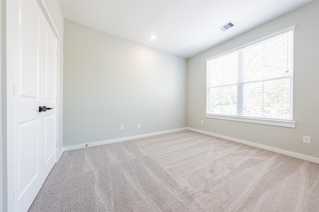 unfurnished room with recessed lighting, baseboards, visible vents, and light carpet