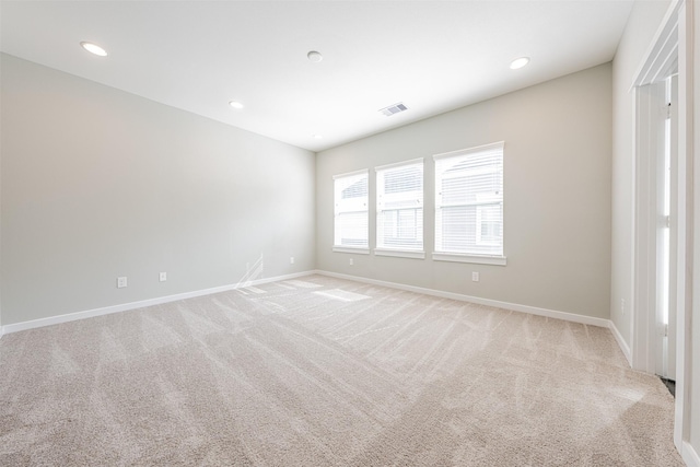spare room with visible vents, recessed lighting, baseboards, and light colored carpet