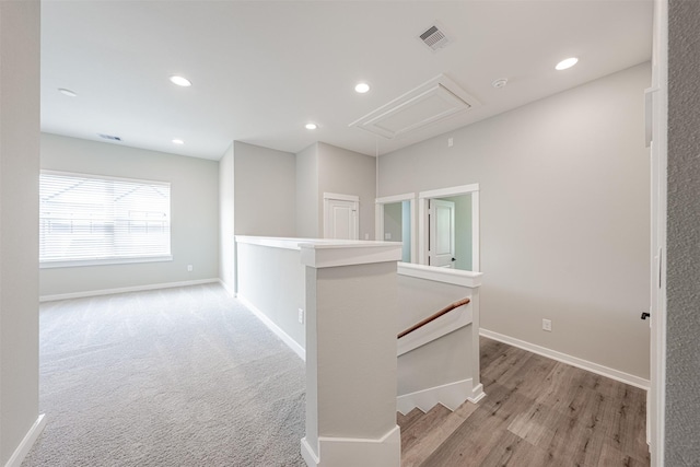 corridor featuring baseboards, attic access, visible vents, and an upstairs landing
