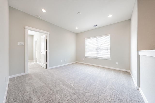 unfurnished room with visible vents, baseboards, and light colored carpet