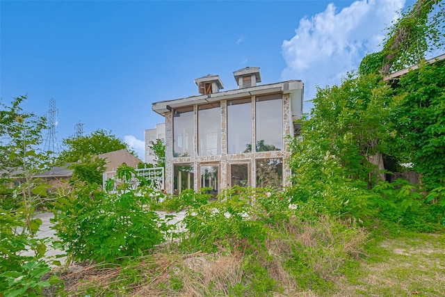 back of property with a sunroom