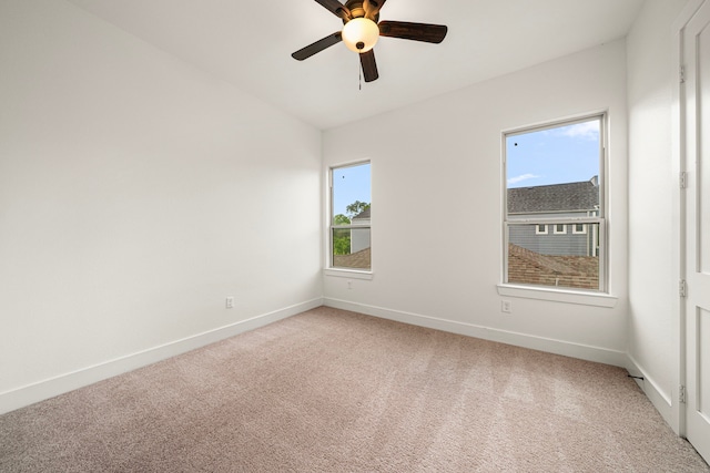 unfurnished room with a ceiling fan, light carpet, and plenty of natural light