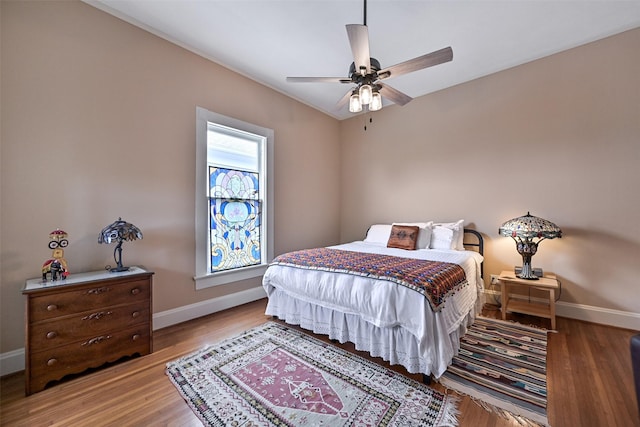 bedroom with baseboards, a ceiling fan, and wood finished floors