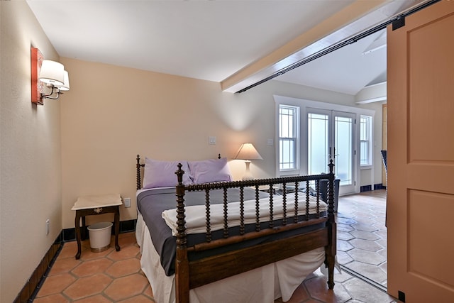 bedroom with light tile patterned flooring, baseboards, and lofted ceiling