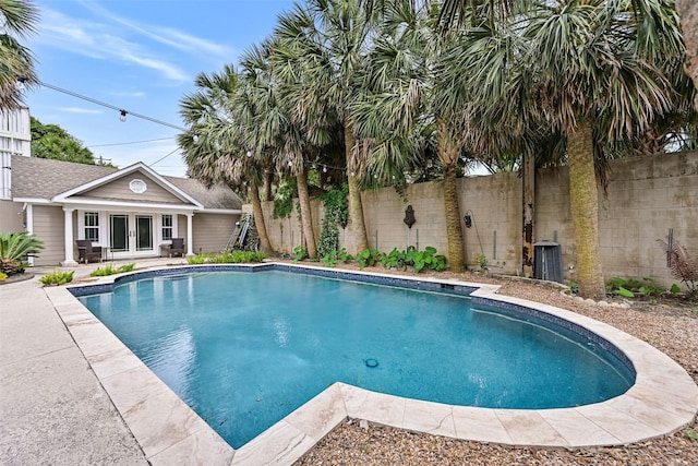 view of pool with a fenced in pool, central AC unit, fence, and french doors