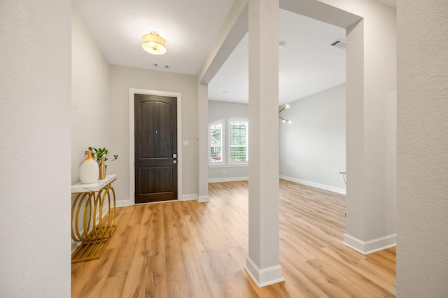 foyer entrance featuring baseboards, visible vents, and light wood-style floors