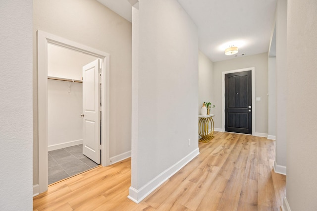 corridor with baseboards and wood finished floors