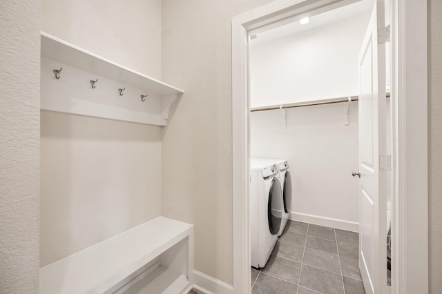 laundry area with laundry area, washing machine and dryer, baseboards, and tile patterned flooring
