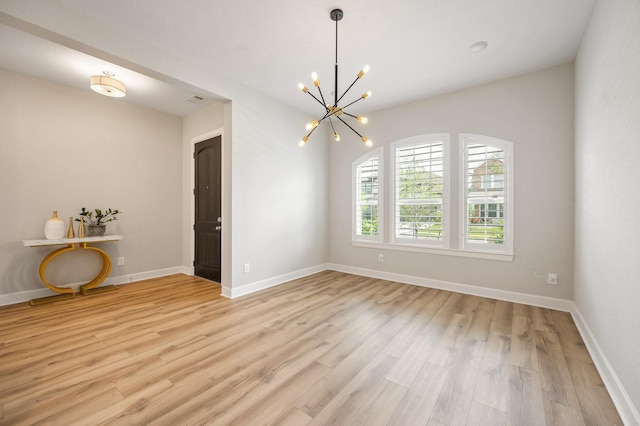 unfurnished dining area with light wood-type flooring, baseboards, and a chandelier