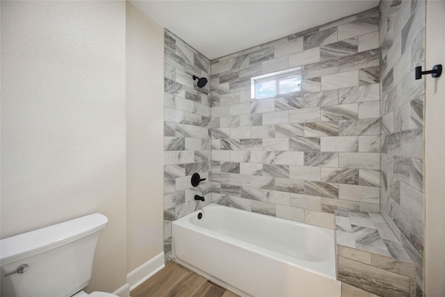 full bath featuring baseboards, shower / bathing tub combination, toilet, and wood finished floors