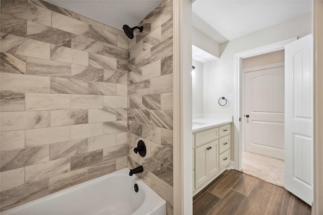 bathroom featuring vanity, wood finished floors, and shower / washtub combination