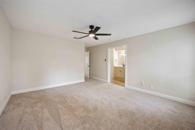 unfurnished bedroom with baseboards, ceiling fan, light carpet, and ensuite bathroom