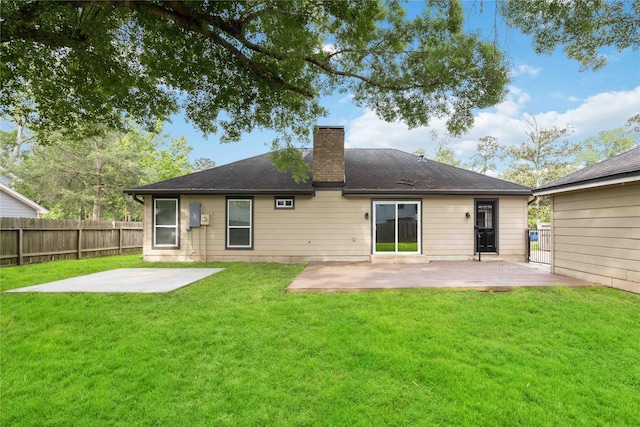 back of property featuring a patio, a lawn, fence, and a chimney