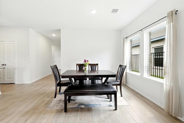 dining room featuring baseboards, visible vents, and light wood finished floors