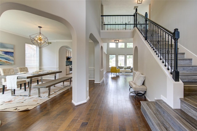 7206 Fountain Mdw, Katy, TX 77494 - foyer entrance featuring a high ceiling, arched walkways, dark wood finished floors, a chandelier, and stairs