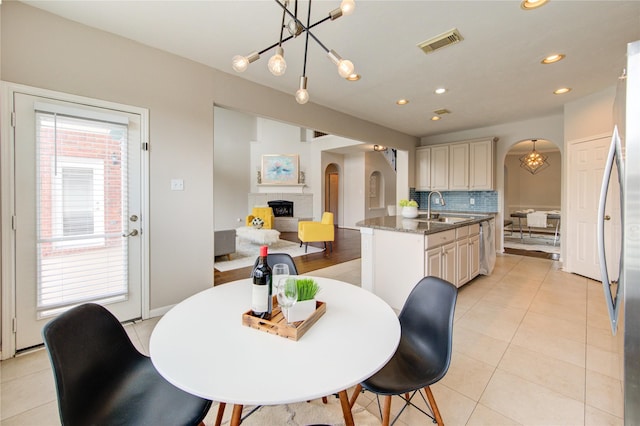 7206 Fountain Mdw, Katy, TX 77494 - dining area with an inviting chandelier, arched walkways, recessed lighting, light tile patterned floors, and visible vents