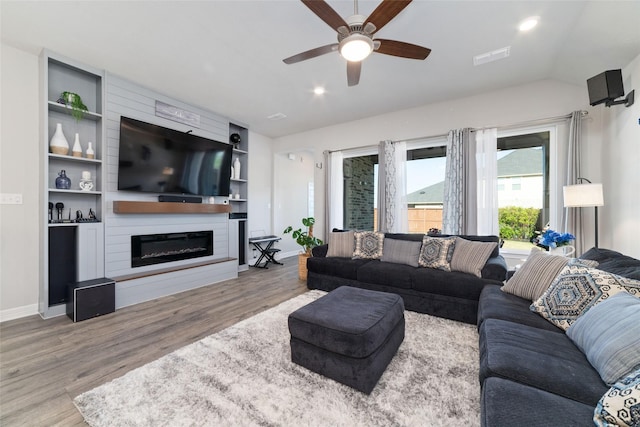 3040 Cirrus Heights Ct, Katy, TX 77493 - living area featuring wood finished floors, ceiling fan, a large fireplace, baseboards, and vaulted ceiling