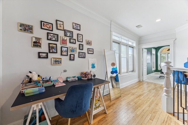 office area with crown molding, light wood-style flooring, baseboards, and visible vents