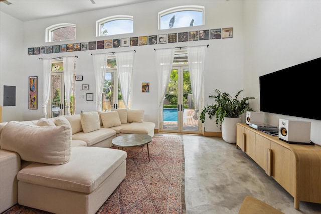 living room featuring a towering ceiling and concrete flooring