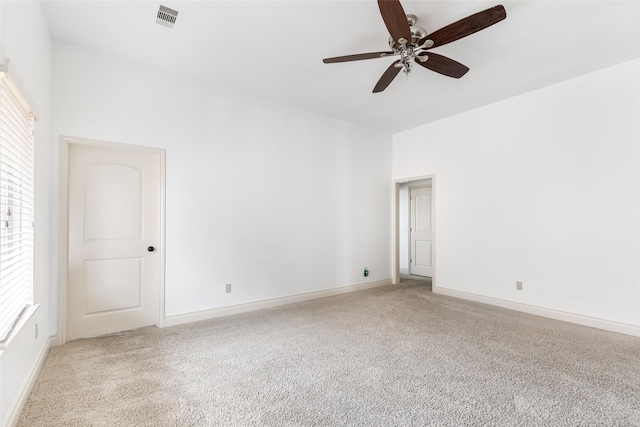 carpeted empty room with ceiling fan, visible vents, and baseboards