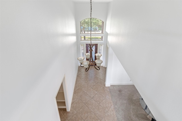 entrance foyer featuring a high ceiling, an inviting chandelier, and light tile patterned floors