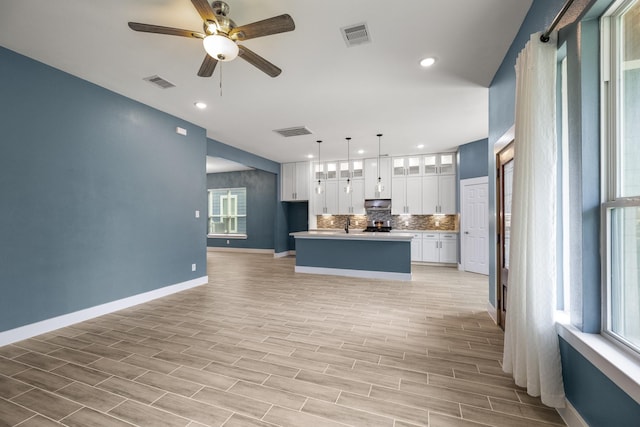 4610 Cashel Glen Dr, Houston, TX 77069 - kitchen with visible vents, white cabinetry, ceiling fan, and backsplash
