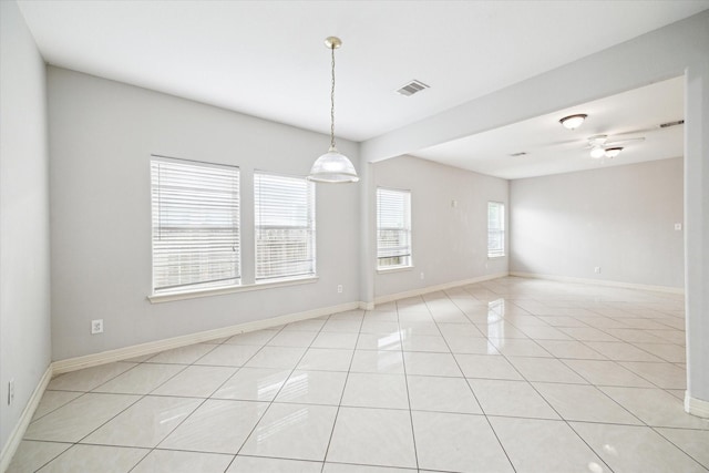 spare room featuring baseboards, visible vents, and light tile patterned floors
