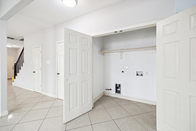 clothes washing area with light tile patterned floors, laundry area, hookup for a gas dryer, and electric dryer hookup