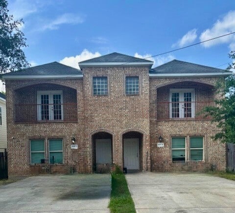 view of front facade featuring concrete driveway and brick siding