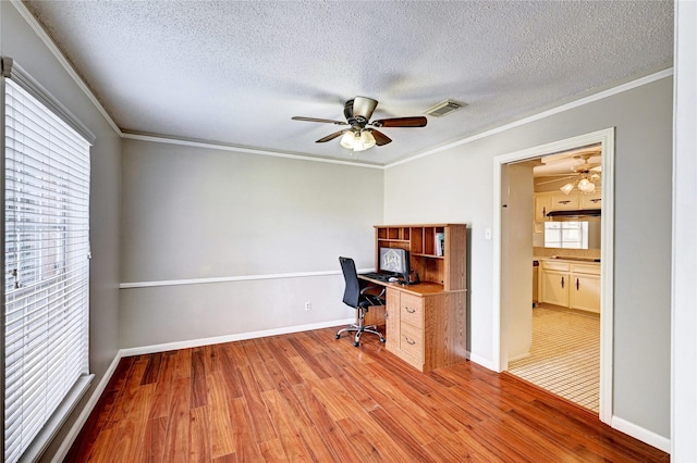 unfurnished office with plenty of natural light, wood finished floors, and visible vents