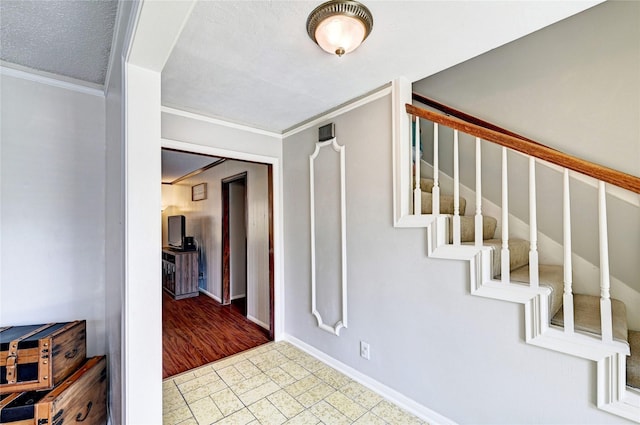 entrance foyer featuring crown molding, stairs, and baseboards