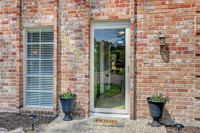 doorway to property featuring brick siding