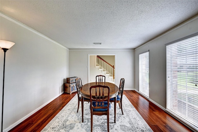 dining room featuring visible vents, crown molding, stairway, dark wood-type flooring, and a textured ceiling